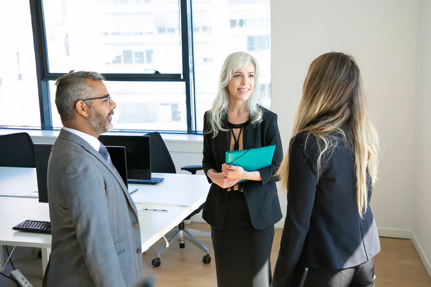 Business professionals discussing "Do I Need Directors and Officers Insurance" in a modern office setting.