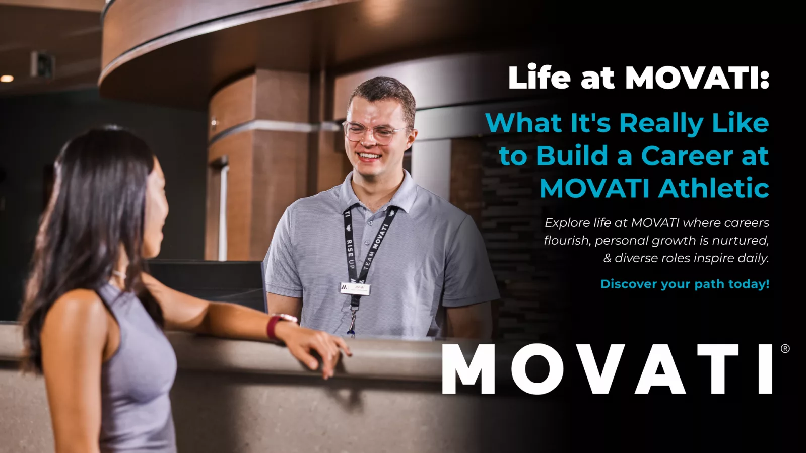 Man and woman smiling at a MOVATI reception desk, showcasing life at MOVATI.