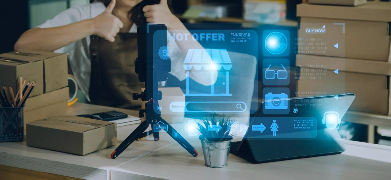 Small business owner recording content beside shipping boxes with AI interface graphics showing automated business workflows in 2026.
