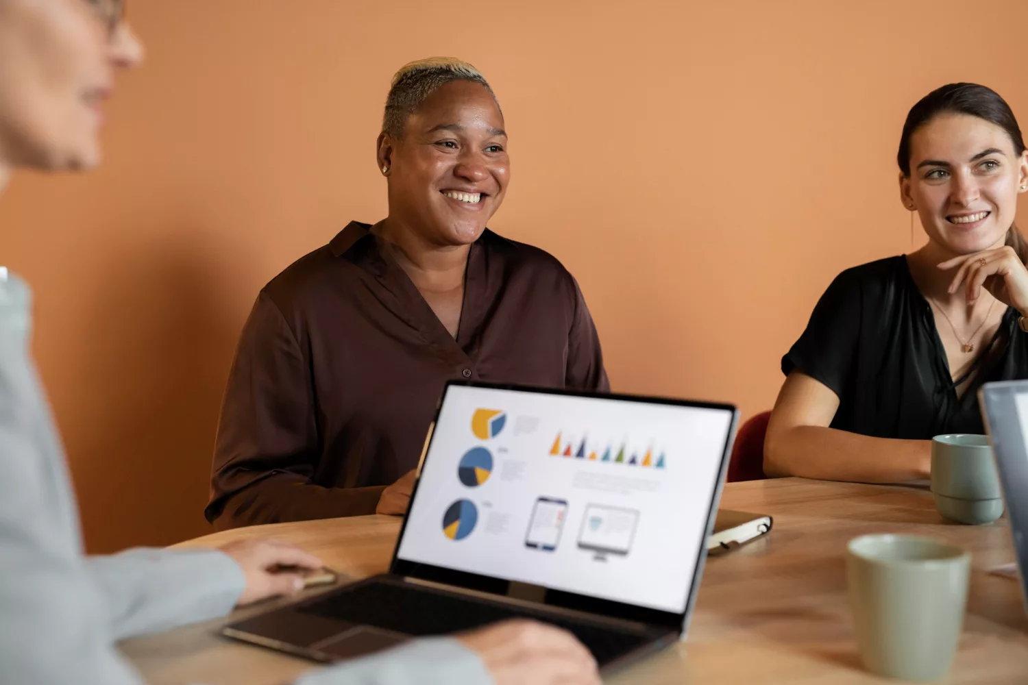 Marketing team reviewing analytics charts on a laptop during a meeting about 2026 B2B marketing benchmarks and ROI performance.
