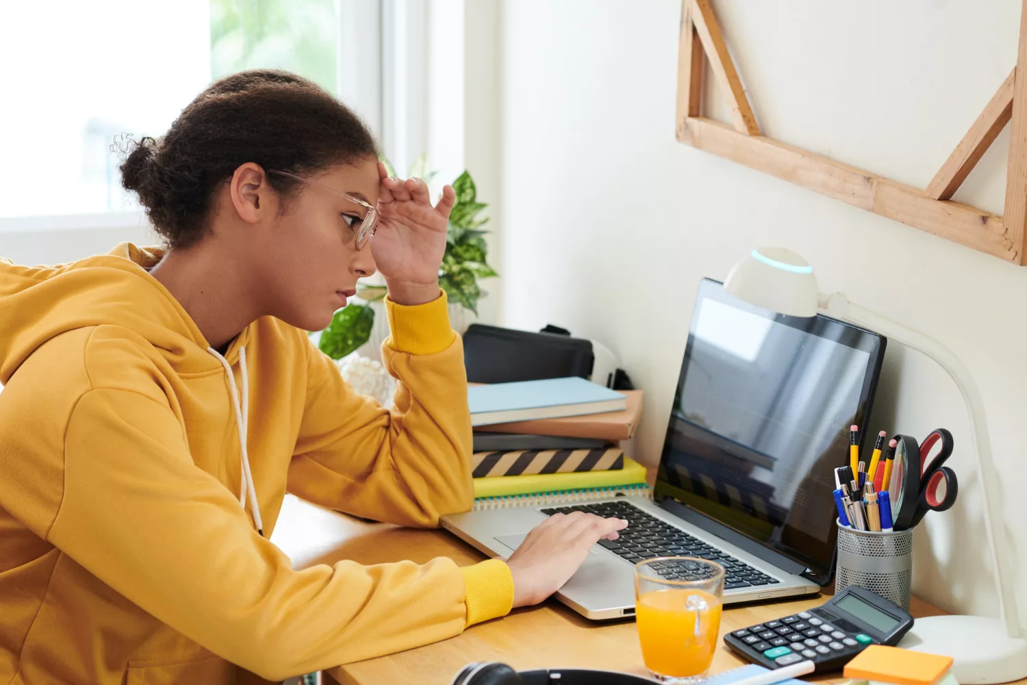 Person troubleshooting Google Ads location extensions on a laptop at a home office desk while reviewing campaign settings.