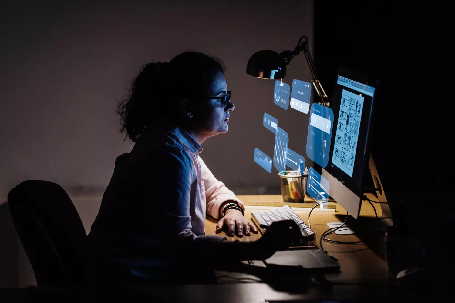 Small business AI workplace automation tools displayed on digital dashboards as a professional manages workflows and data analysis at a computer.