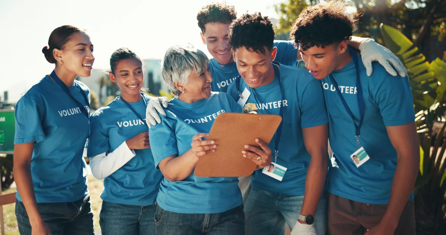 Group of nonprofit volunteers reviewing information together outdoors, illustrating collaboration, digital marketing growth, and nonprofit mission expansion through Google Ad Grants.